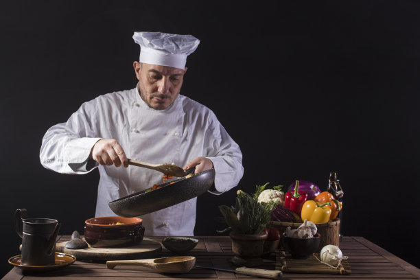 男厨师穿着白色制服，准备菜盘图片下载
