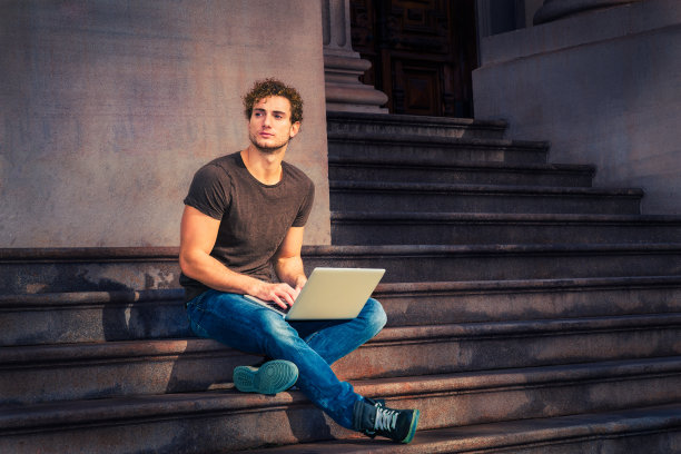 一个在纽约户外用笔记本电脑工作的年轻人图片下载