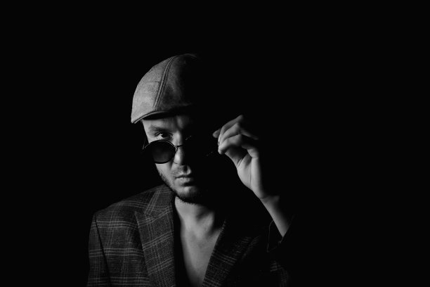 优雅的时尚男士，留着复古风格的胡须。自信的男人穿着时髦的复古衣服。穿着复古的衣服，戴着复古的帽子，沉思着。复古时尚——男士西装、衬衫、马甲、帽子图片下载