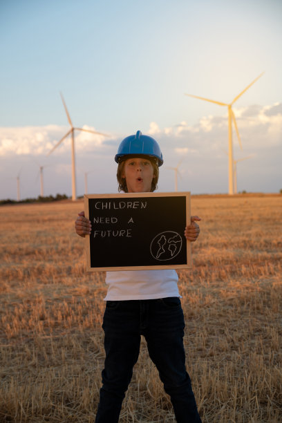 儿童工程师研究和分析风背景中的风车，农场的日落。儿童对儿童未来的要求。海报儿童需要一个未来图片下载