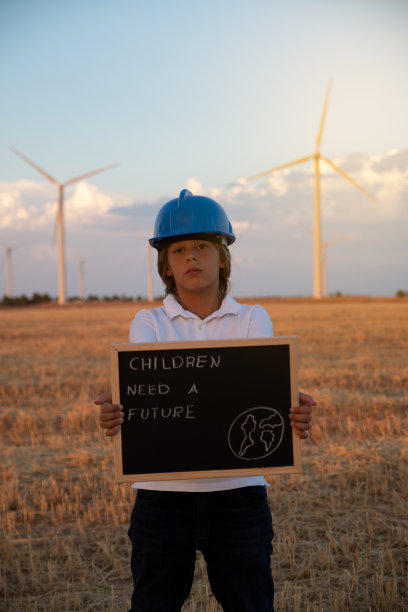 儿童工程师研究和分析风背景中的风车，农场的日落。儿童对儿童未来的要求。海报儿童需要一个未来图片下载