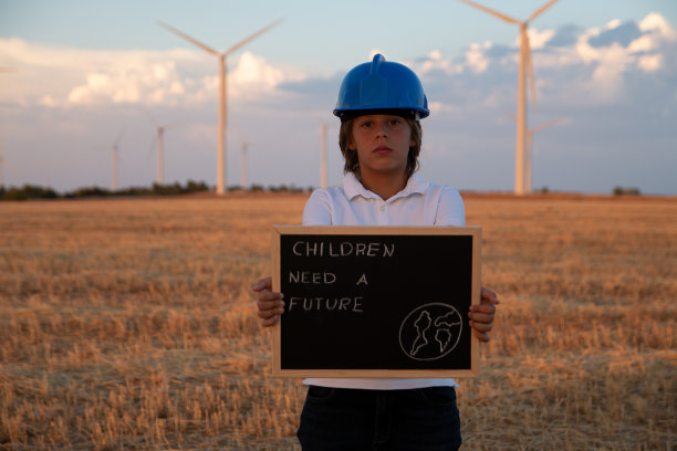 儿童工程师研究和分析风背景中的风车，农场的日落。儿童对儿童未来的要求。海报儿童需要一个未来图片下载