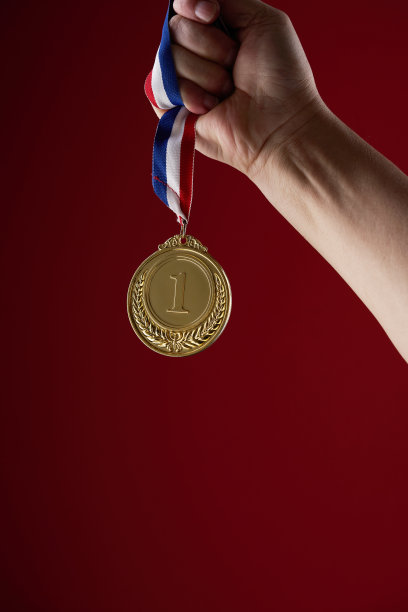 手拿金牌对红色背景图片下载