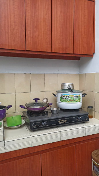 厨房顶部有炉子和锅。挂在墙上或墙上作为存放货物的地方的木制橱柜。现代住宅的脏厨房概念。图片下载