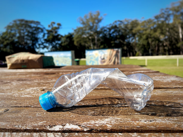 木桌上放着废塑料瓶子。图片下载