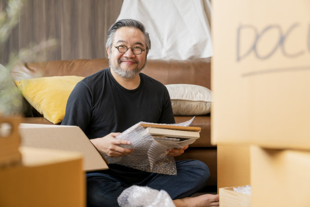 告别老房子，亚洲男成年人看着镜头手势胸有成竹自信地说再见准备好搬家后收拾好行李搬到新家，构思搬家的想法素材图片