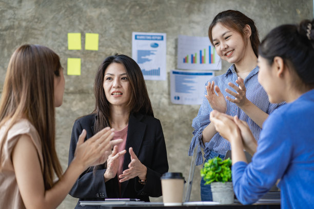 年轻的创意团队同事四个女人在会议室里讨论创意。一群亚洲妇女在开办公室业务的头脑风暴会议期间。图片下载