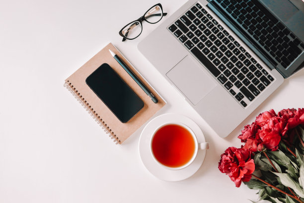 工作场所俯视图，笔记本电脑，一杯茶，手机，牡丹，眼镜图片下载