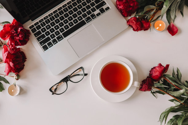 俯视女性工作场所，笔记本电脑，一杯茶，牡丹，眼镜图片下载