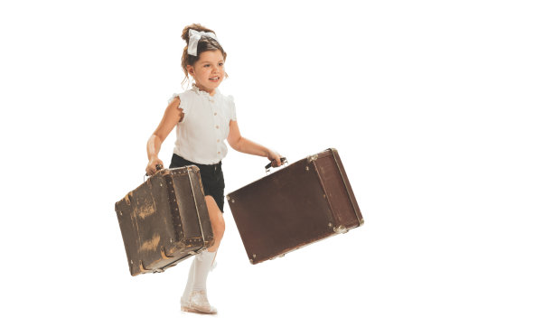 一个美丽的小女孩，快乐的孩子跑步与复古手提箱孤立在白色的工作室背景。复古复古的风格概念。假期,假期,旅行图片下载