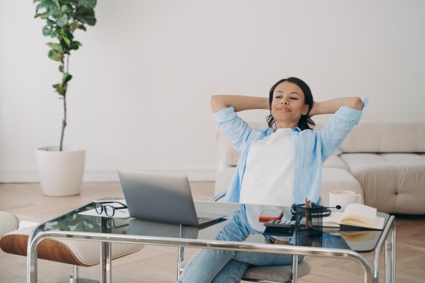 微笑的女商人在成功的工作后休息，放松坐在办公桌上的笔记本电脑图片下载