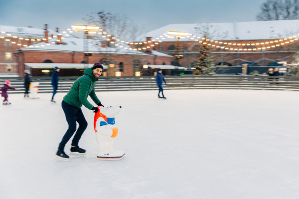 人，假期，冬天，休闲概念。快乐的大胡子男子滑冰花星期六在滑冰圈，练习和学习新的技巧，娱乐自己，处于良好的节日情绪。图片下载