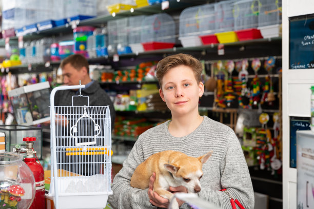 一个男孩带着狗在宠物店的肖像，背景是一个男人图片下载