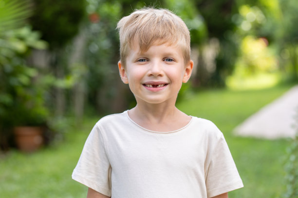 微笑的学龄缺牙男孩的肖像，缺了四颗门牙图片下载