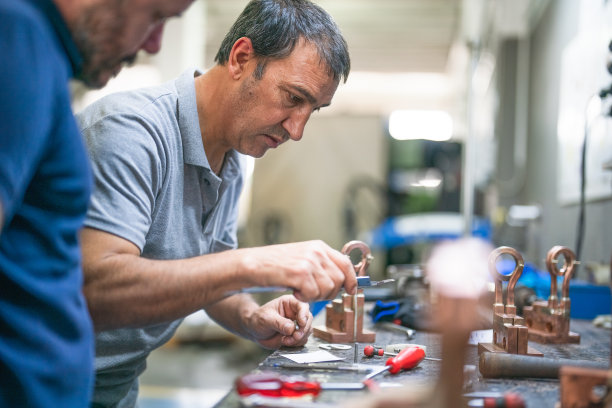 正在加工金属零件的蓝领工人和设计师图片下载