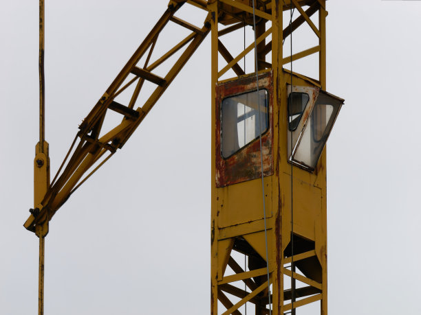 一张黄色塔吊的特写照片，背景是明亮的天空图片下载