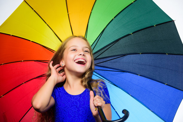 小女孩在雨天里打着伞。快乐的小女孩，秋季时尚，儿童，快乐的童年，上学时光。在秋日感到被保护，一起享受秋天图片下载