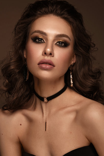 美丽的女孩与明亮的时尚化妆和金色的配件。美丽的脸。图片下载