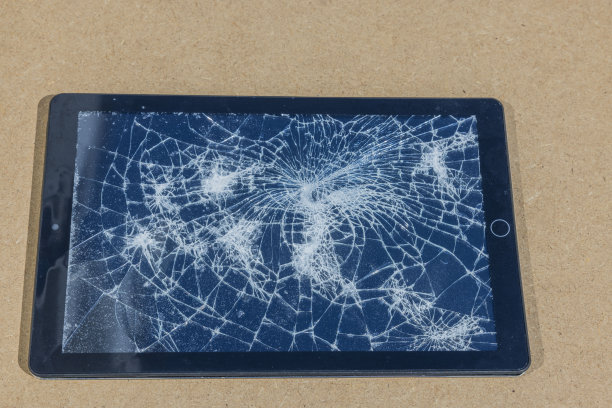 电子平板电脑与损坏的屏幕孤立在灰色背景。图片下载