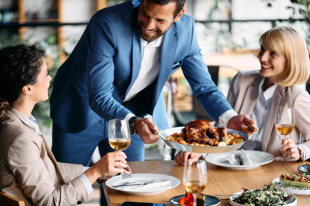 快乐的商人在餐厅午餐期间为女同事提供食物。图片下载