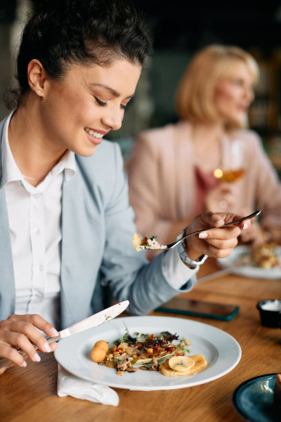 年轻的女商人享受与同事在餐厅午餐。图片下载