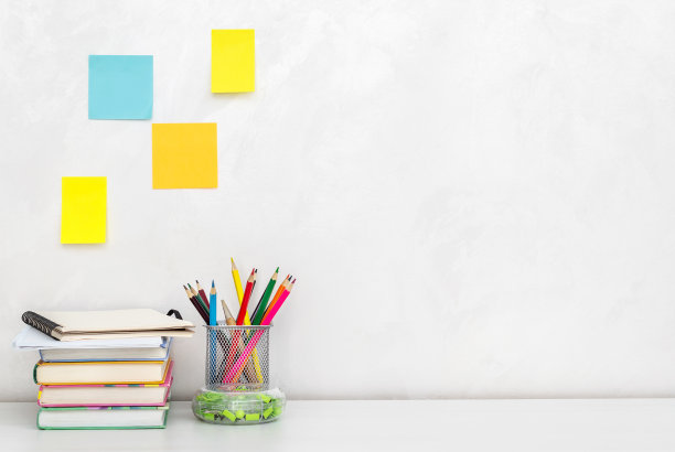 彩色铅笔在铅笔盒里，书在靠墙的桌子上。副本的空间。图片下载