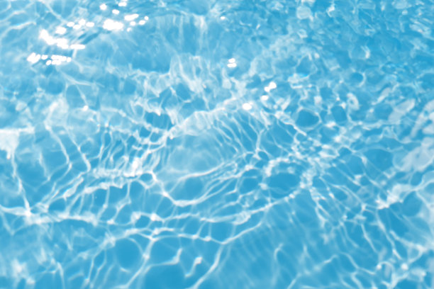 散焦模糊透明蓝色，清澈平静的水面纹理与飞溅和泡沫。时髦的抽象自然背景。阳光下的水波与复制空间。蓝色水彩纹理图片下载