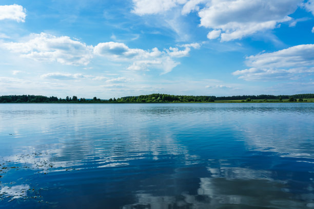 从船上望向湖面，平滑的水面映出蓝天白云图片下载