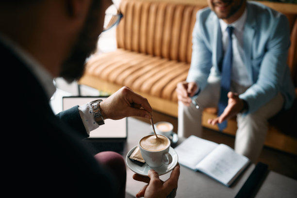 企业家在咖啡馆开商务会议时喝咖啡的特写。图片下载