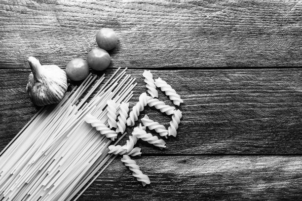 意大利面，圣女果和大蒜放在木板上。图片下载