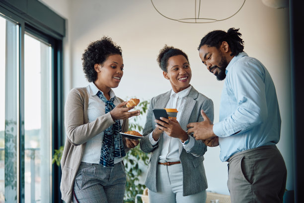 一群黑人同事在办公室喝咖啡的时候打手机。图片下载