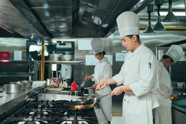 后厨内的专业厨师团队烹饪美味佳肴图片下载