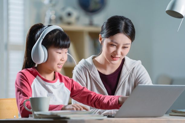 年轻妈妈辅导女儿上网课图片下载