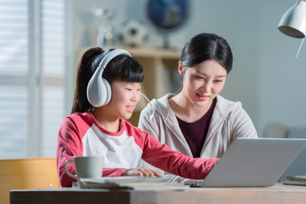 年轻妈妈辅导女儿上网课图片下载