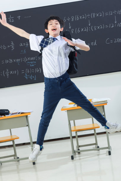 快乐的小学男生在教室里欢呼跳跃图片下载