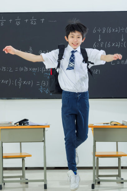 快乐的小学男生在教室里欢呼跳跃图片下载