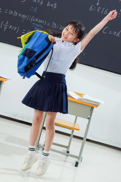 快乐的小学女生在教室里欢呼跳跃图片下载