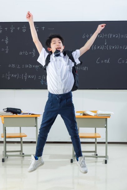 快乐的小学男生在教室里欢呼跳跃图片下载