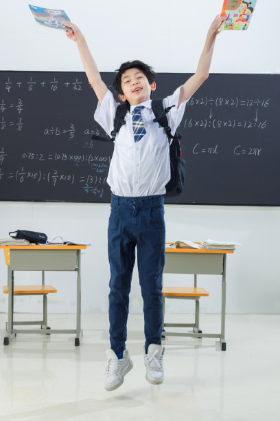 快乐的小学男生在教室里欢呼跳跃图片下载