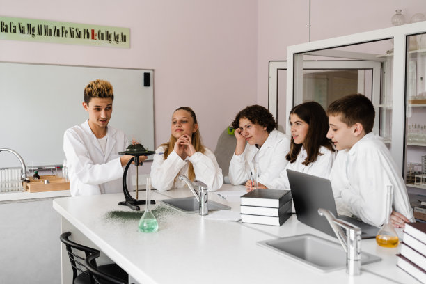 实验用火。学校化学老师在实验室给孩子们做实验。教育的概念。化学课上同学们的集体课。图片下载