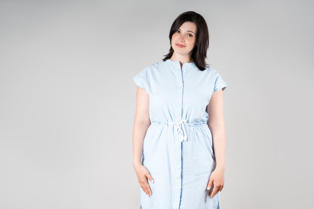 可爱加尺码的模特在休闲服装，胖女人在灰色的背景，超重的女性身体图片下载