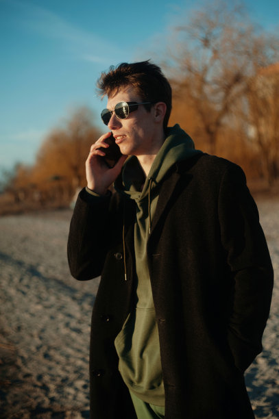 一个年轻人在海滩上打电话图片下载