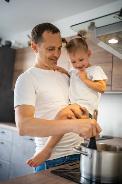 父亲和他的女儿在他的手上一起煮汤在现代家庭厨房图片下载