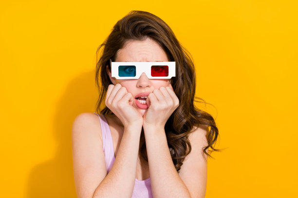 照片惊吓可爱的女人穿粉红色上衣看3d恐怖电影孤立的黄色背景图片下载