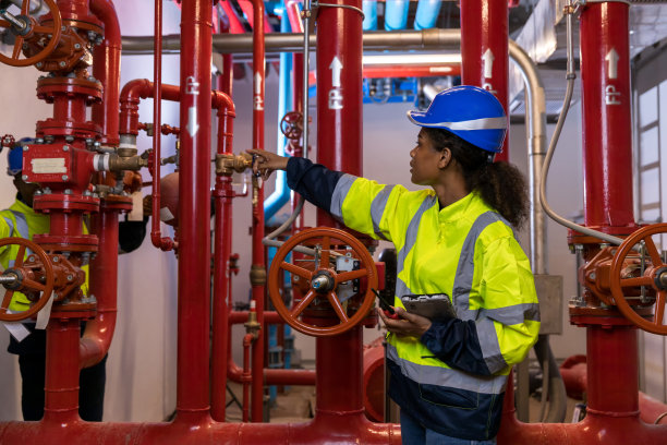 检查消防系统和消防设备的工程师或技术员工作。工程师检查红色发电机泵的喷水灭火系统和火灾报警控制系统图片下载