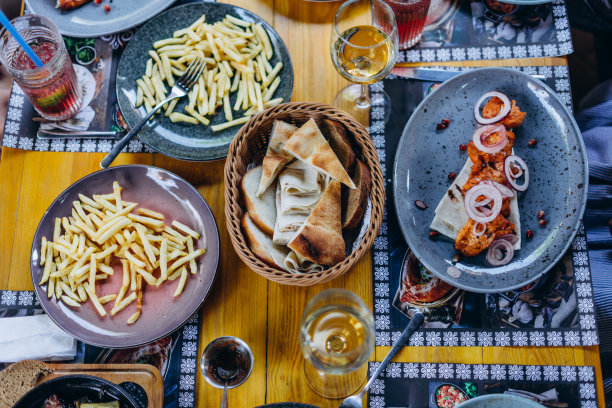 桌子上的菜、饮料和服务都是从上面拍摄的。餐厅餐桌上的烤肉，沙拉，薯条，夏巴塔面包，葡萄酒。餐厅午餐摄于上方。图片下载