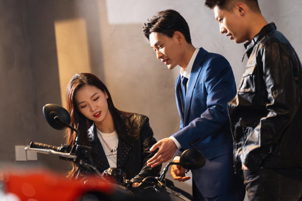 摩托车销售人员为青年伴侣介绍图片下载
