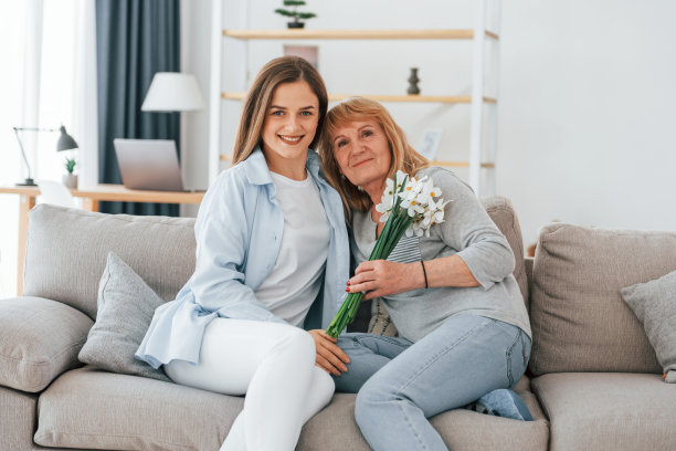 手里拿着花。母亲节快乐。老太太和女儿一起在家图片下载