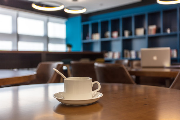 现代企业内部共享的休息室空间，木桌，扶手椅，咖啡和笔记本电脑图片下载