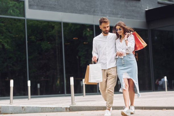走在现代建筑附近。一对美丽的夫妇白天在户外购物图片下载